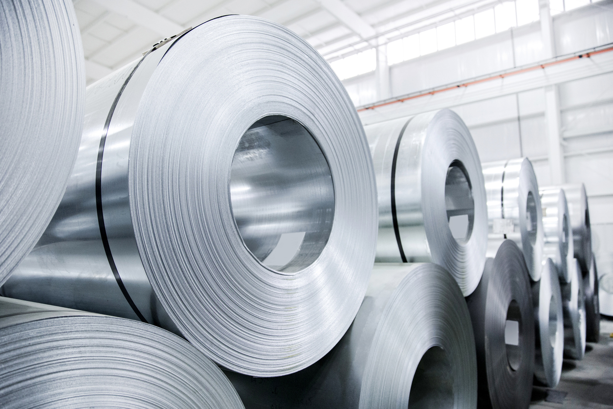 rolls of sheet metal stacked on top of each other in a warehouse